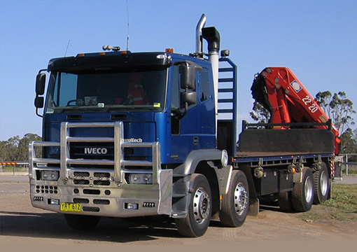 Blue Iveco flatbed truck with mounted crane